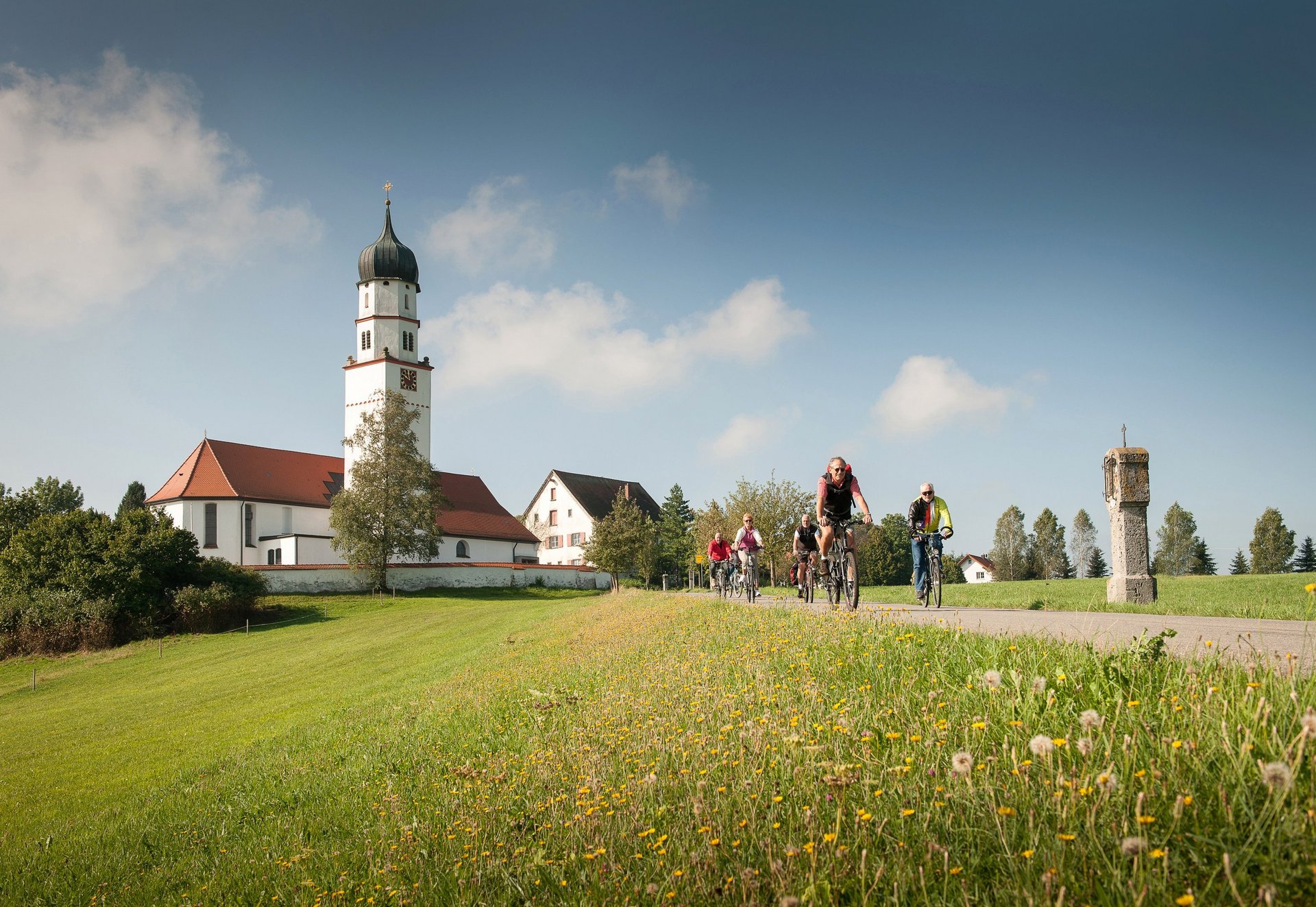 Radfahrer auf Radweg vor Kirche